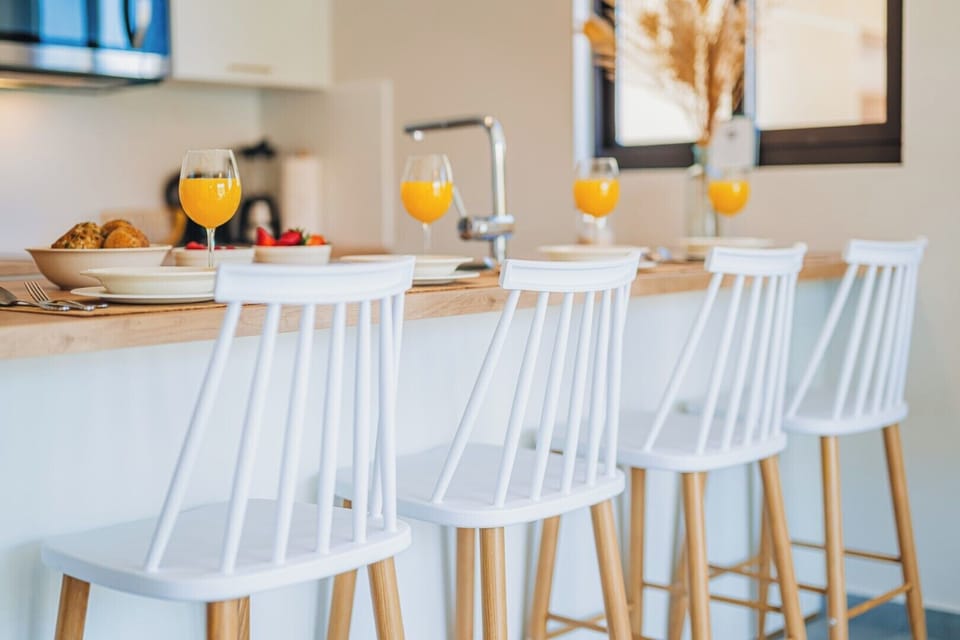 Bar-style dining with sleek white stools and cozy lighting—perfect for casual bites or evening drinks.

