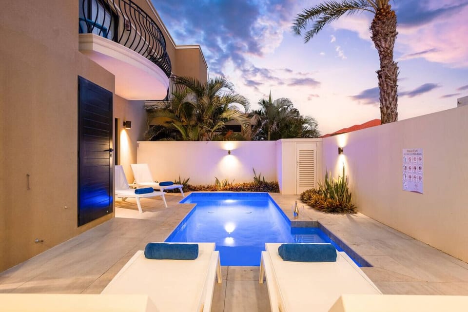 Walled garden pool with palms, perfect for evening relaxation.