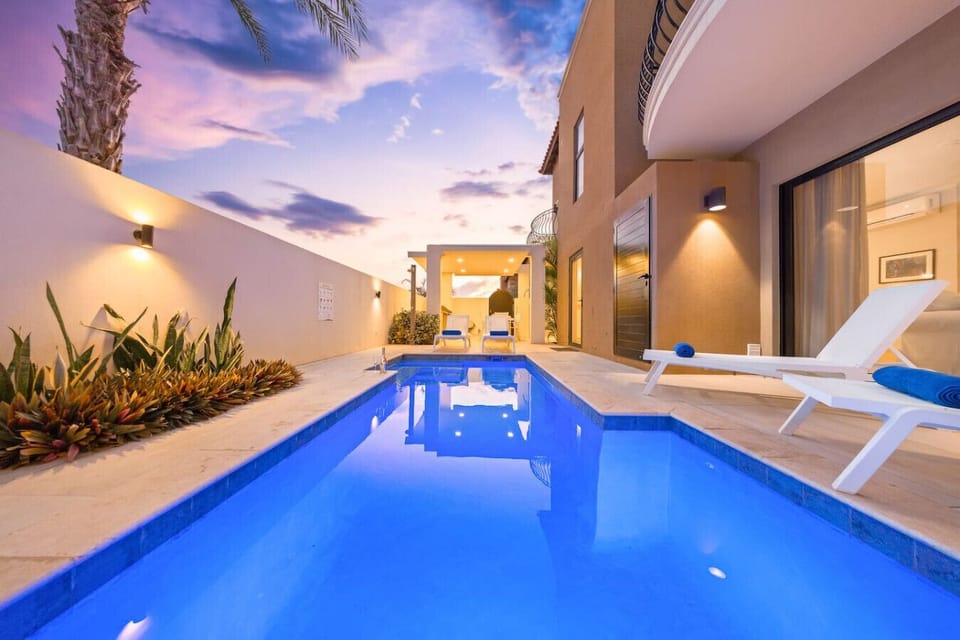Swim under glowing lights in your private midnight-blue pool escape.