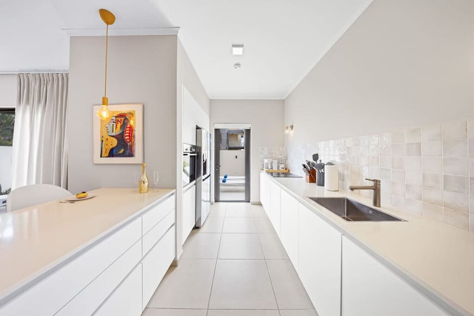 Fully equipped kitchen with built-in oven, wide counters, and pendant lights.