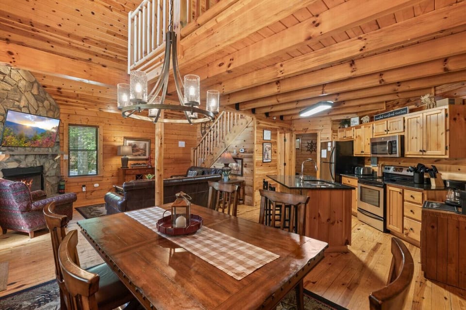 Gather around the large dining table, perfectly positioned near the front door and windows for warm natural light and cozy cabin ambiance.