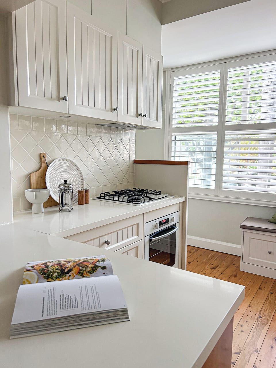 Full gourmet kitchen drenched in light from enormous windows.