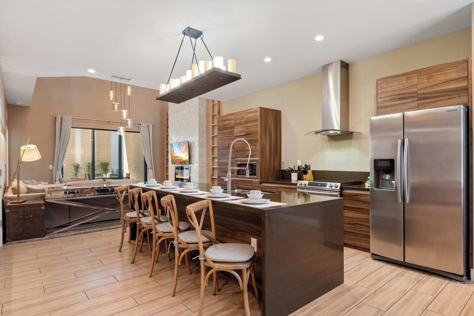 Elegant kitchen with wood cabinetry, spacious island seating, and bright patio access.