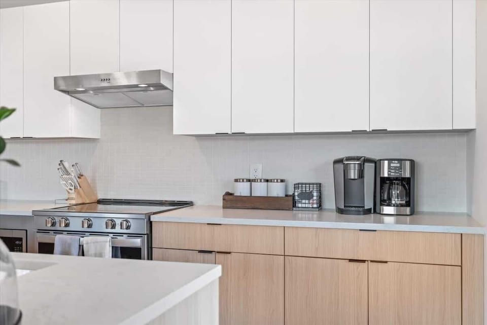 Fully equipped kitchen with white cabinetry and stainless steel appliances