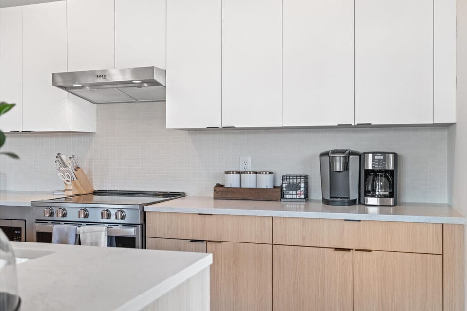 Fully equipped kitchen with white cabinetry and stainless steel appliances