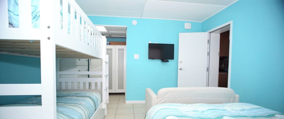 Left bedroom with Queen Bed, bunk bed, and small settee 