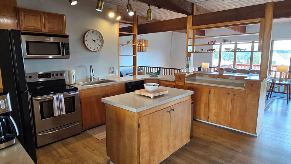 Large, fully stocked kitchen with electric stove, microwave, dishwasher