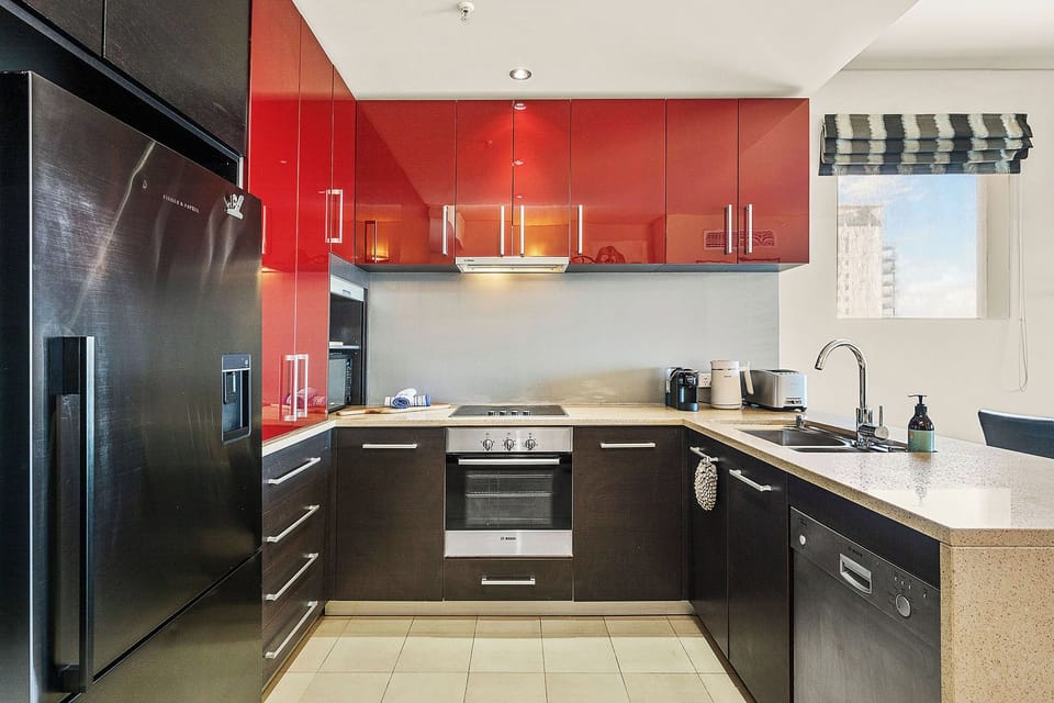 A modern, well-equipped kitchen featuring sleek appliances and a striking color palette for convenient meal preparation.