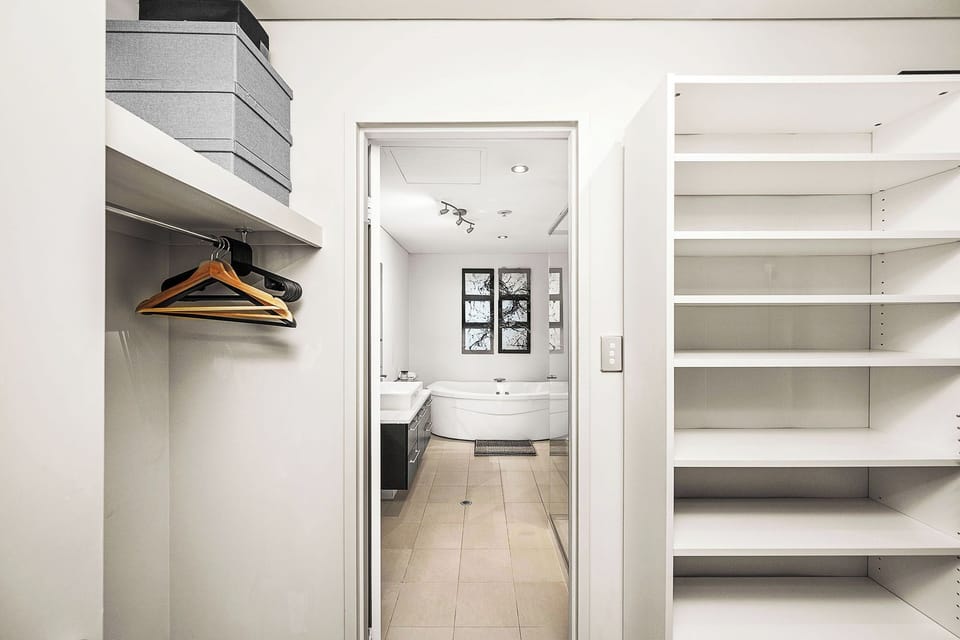 Organized walk-in closet seamlessly transitions to a spa-inspired bathroom.