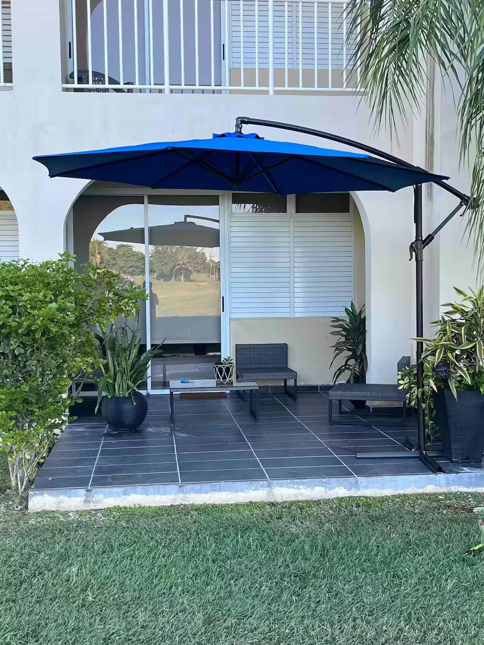Terrace with patio umbrella and outdoor seats.