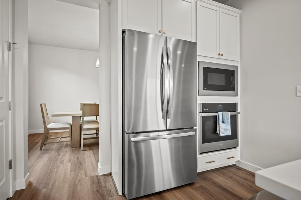 Cook like a pro with stainless steel appliances, a gas stove, large refrigerator, and built-in oven—all seamlessly integrated into this stylish, functional layout.