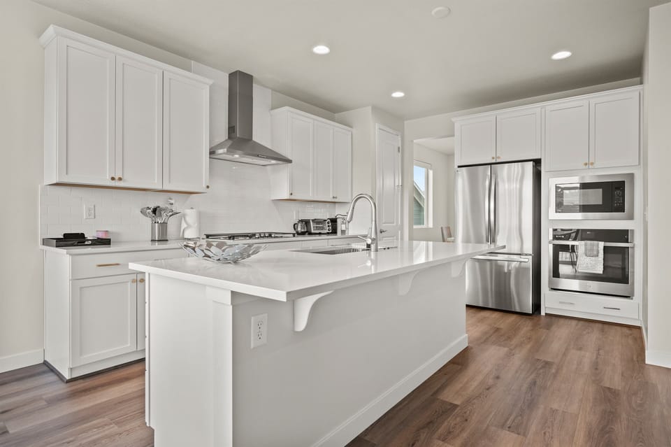 A spacious kitchen island anchors the room, offering extra prep space and seating for casual meals or morning coffee.