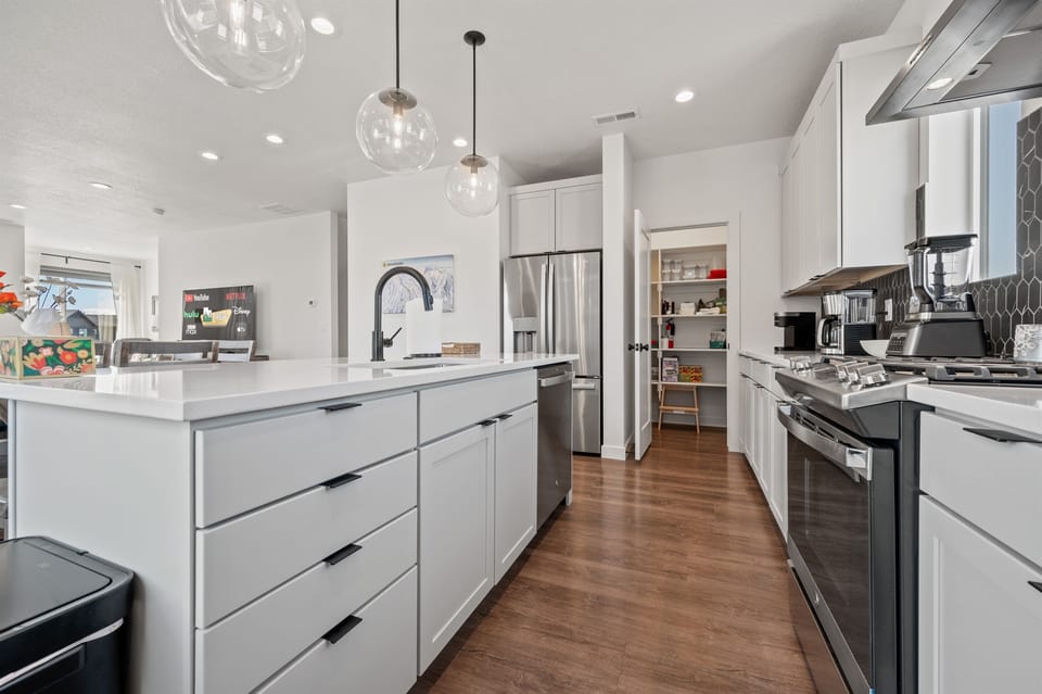 Recessed lighting, paired with pendant lights over the island, brightens the space beautifully.