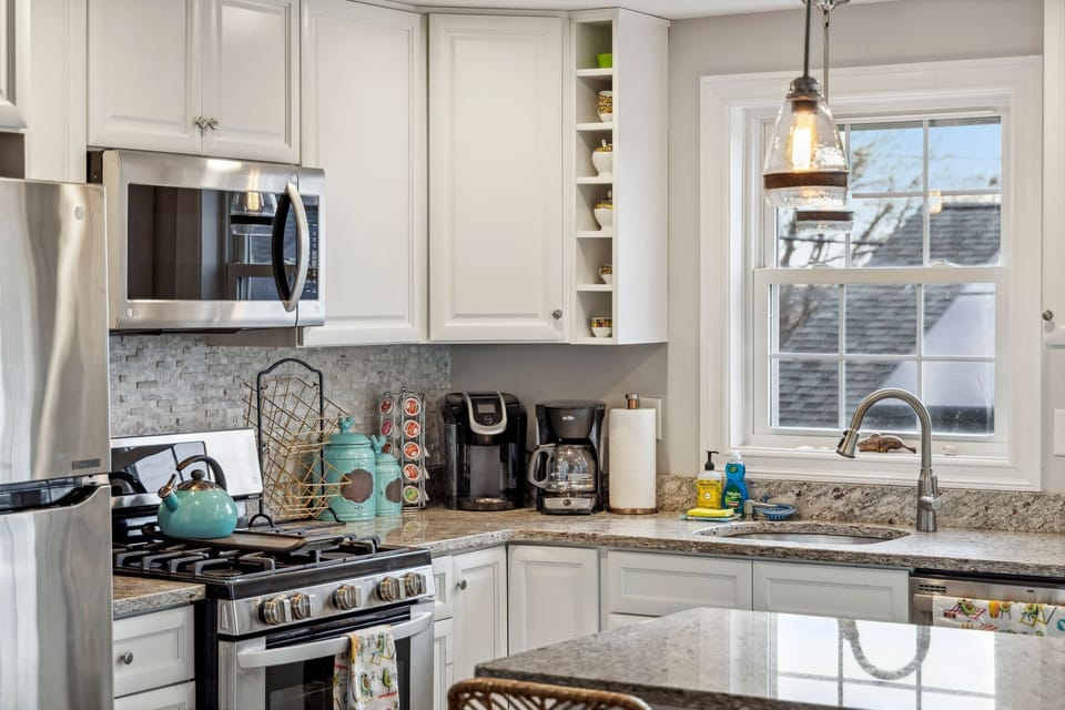 Fully equipped kitchen with updated appliances, coffee provided, and an island with seating for two.