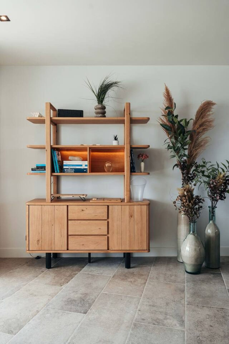 A warm and earthy display of natural tones and textures—this wooden shelf pairs books, decor, and dried florals with effortless balance, bringing charm and character to a minimalist space.