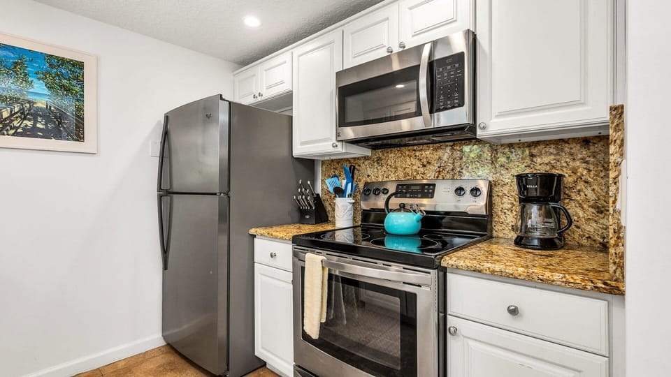 Cozy meals made easy. This well-equipped kitchen opens to a charming dining nook set for four—perfect for breakfast before the beach or a laid-back dinner at home.