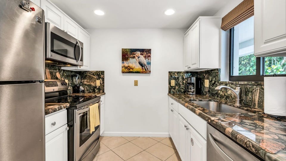 Fully equipped kitchen featuring stainless steel appliances, beautiful stone countertops, a drip coffee maker, toaster, blender, and everything you need to prepare meals at home.