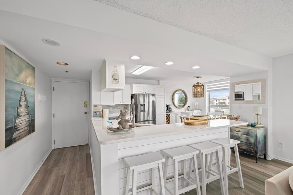 Sleek, modern kitchen with white cabinetry and a breakfast bar.