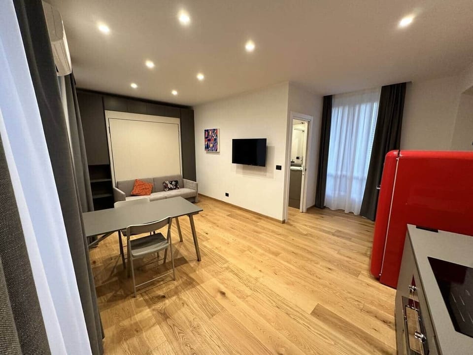 Living room with kitchenette, closet with drop-down bed, balcony on Piol street and SKY TV 