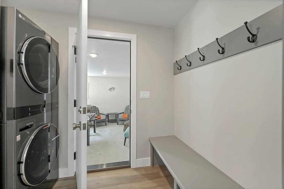 Full-sized stackable LG washer/dryer conveniently right at the garage entryway.