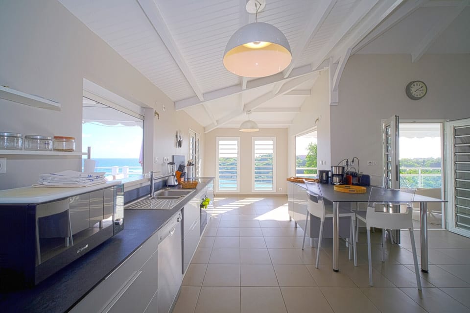 A fully equipped kitchen bathed in light, facing the sea, ideal for cooking beautiful West Indian recipes