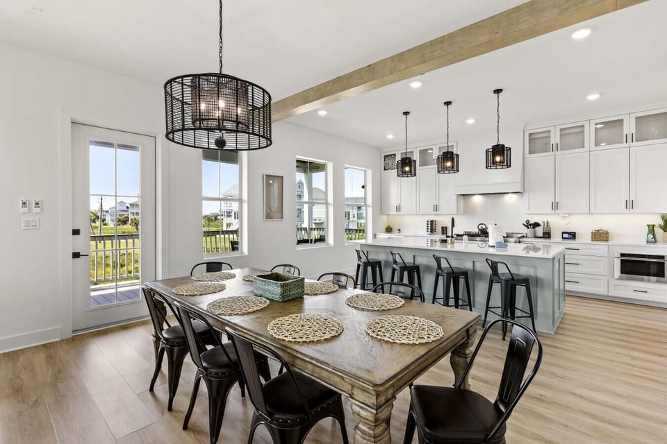 This bright, open-concept space blends the kitchen, dining, and living areas — all styled with a modern coastal touch and plenty of natural light