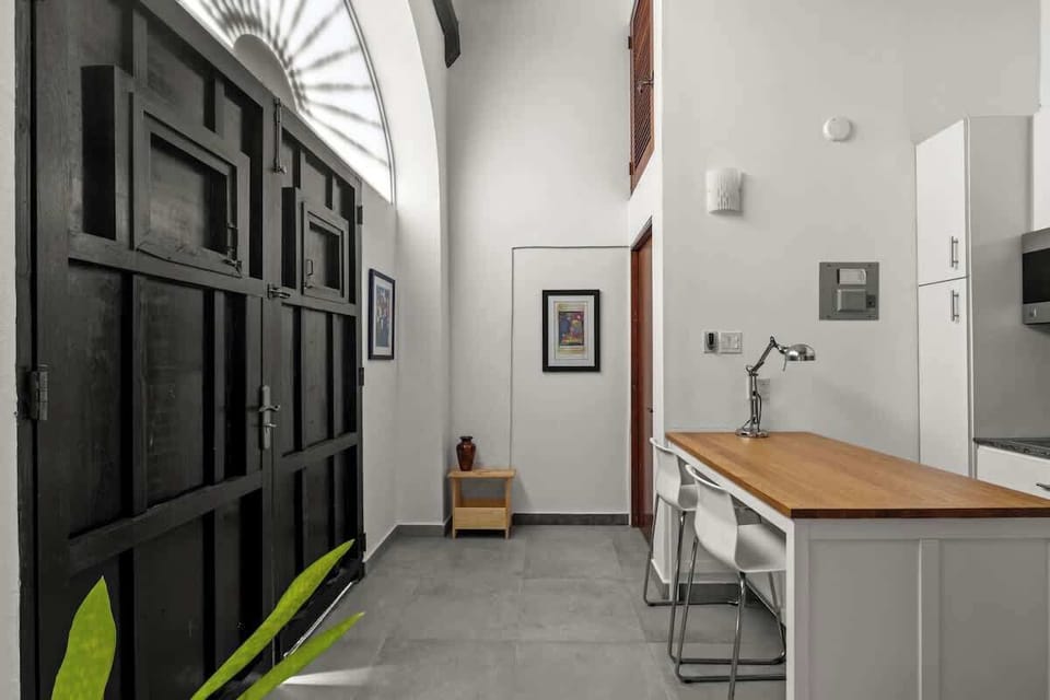 livingroom with kitchen , stainless steel fridge, air conditioner, sofabed, seats, ceiling fan, microwave,  reading lamps, cabinets