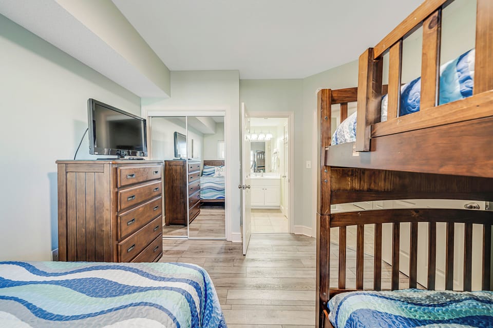 The second bedroom features a full-sized bed, a set of full over full bunks, and its own television.