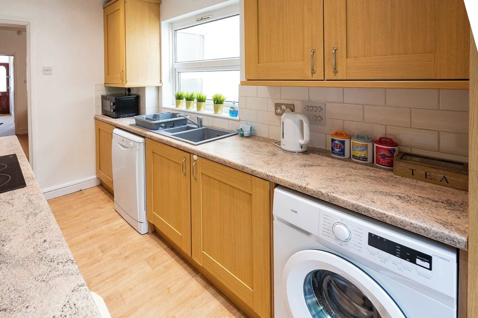 fully equipped kitchen provides all essential amenities, including a hob, oven, crockery, toaster, kettle, washer, and a coffee machine
