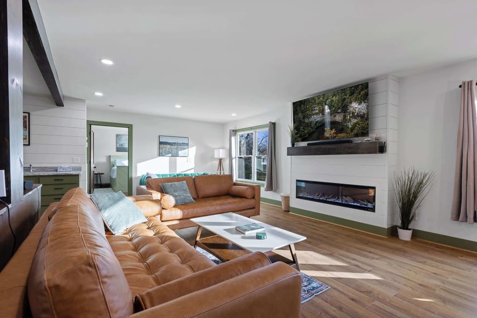 Unwind in comfort with two brown sofas and the warmth of a fireplace.