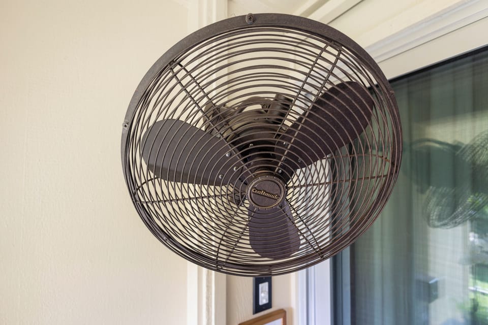 A stylish wall-mounted fan keeps your space cool and comfortable, blending vintage charm with modern convenience for those warm days and nights.