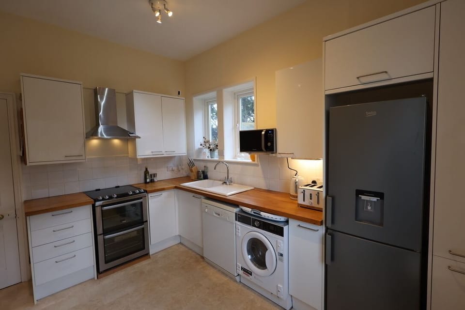Fully fitted kitchen with microwave oven, and two fridges