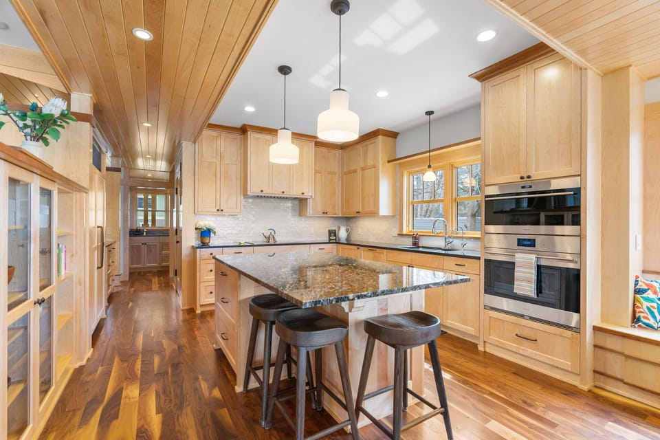 Cook together in your spacious gourmet kitchen, featuring warm wood cabinetry, granite countertops, and modern appliances perfect for creating memorable meals.