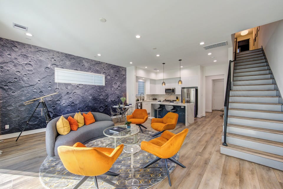 A living room featuring a refracted telescope and a moon-themed wallpaper