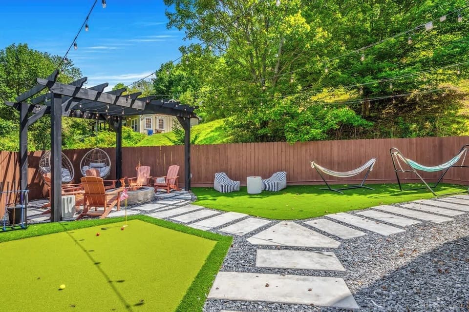 Backyard hangout w/ fire pit seating, mini golf & string lights overhead