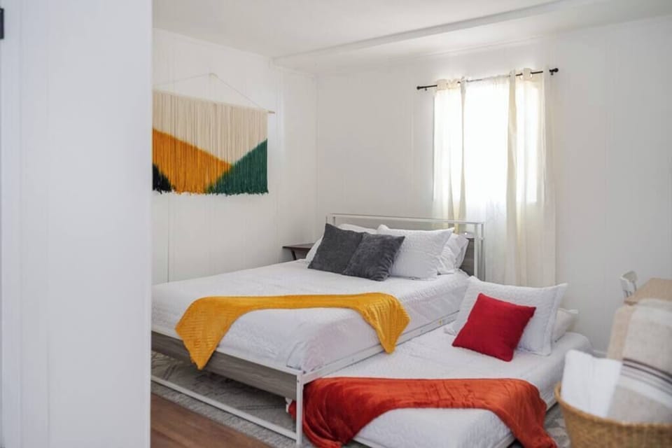 Light-filled bedroom w/ colorful accents & cozy beds for a cheerful stay