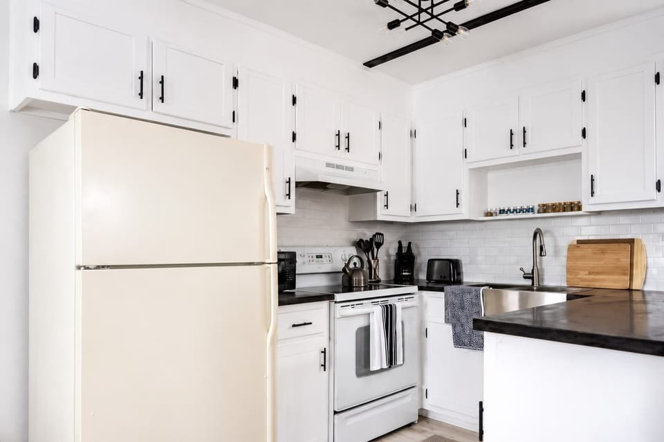 Clean kitchen w/ white cabinetry, full appliances & plenty of prep space