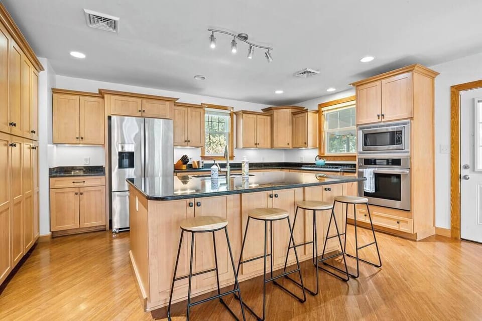 Fully equipped kitchen w/ bar seating and open flow to dining area