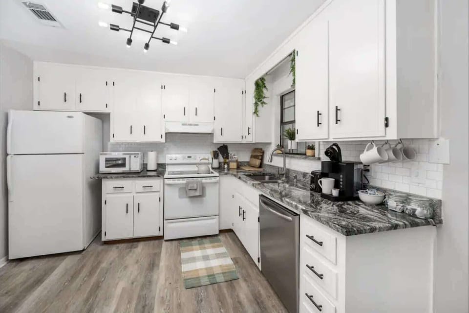 Bright kitchen w/ white cabinetry, ample counter space & modern appliances