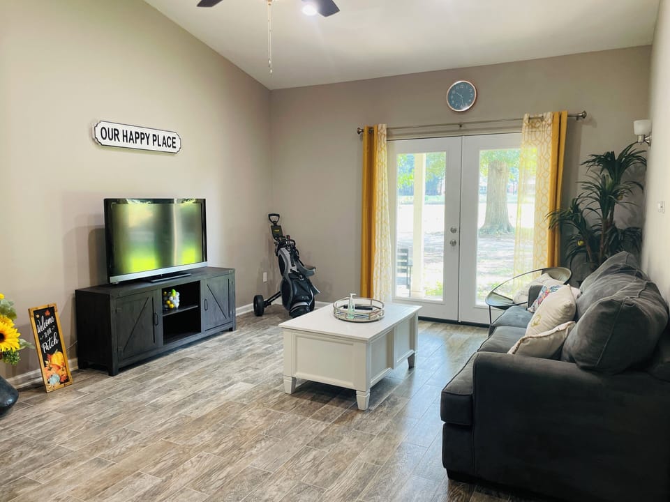 Bright and open living room with double doors leading to covered patio.
