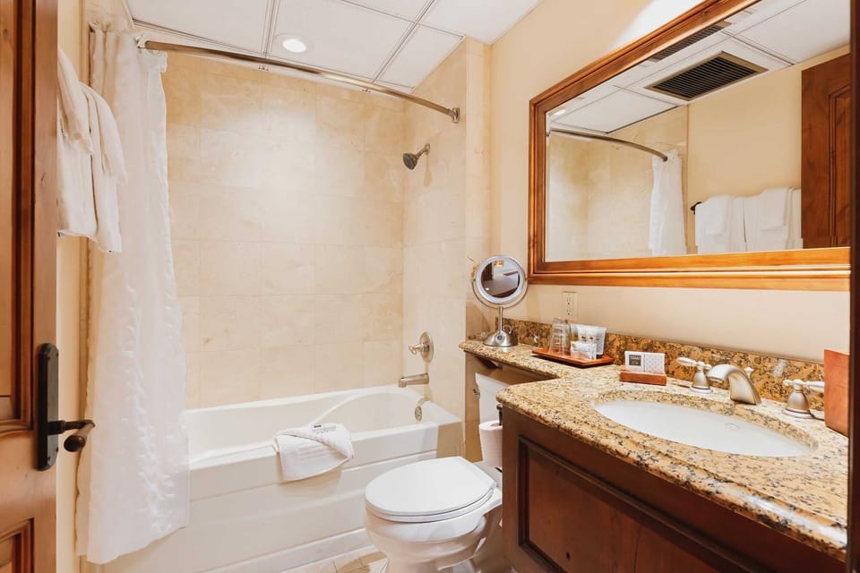 Soak and reset in a bright bath with granite vanity.