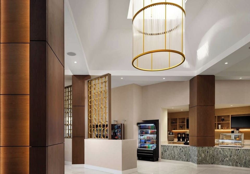 Step into a soaring lobby with elegant, golden lighting.
