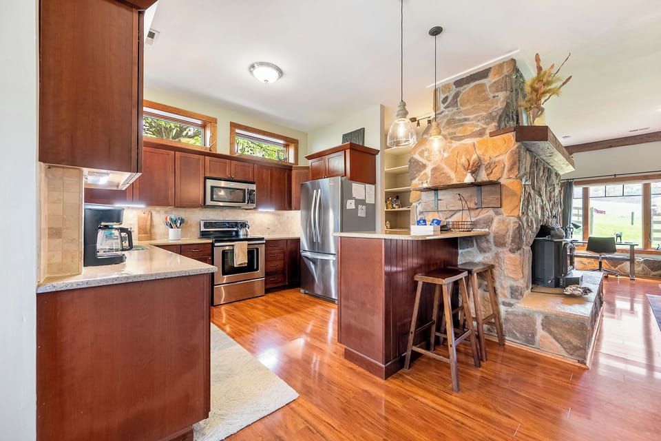 Fully equipped kitchen with bar seating and rustic stone finishes.
