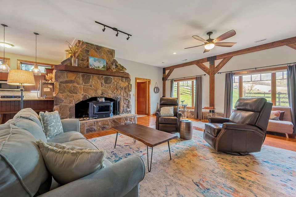 Spacious living room with cozy stone fireplace and natural light.
Has a queen pull out couch, also a futon twin sleeper chair
(Linens are in bedrom 1 closet)
