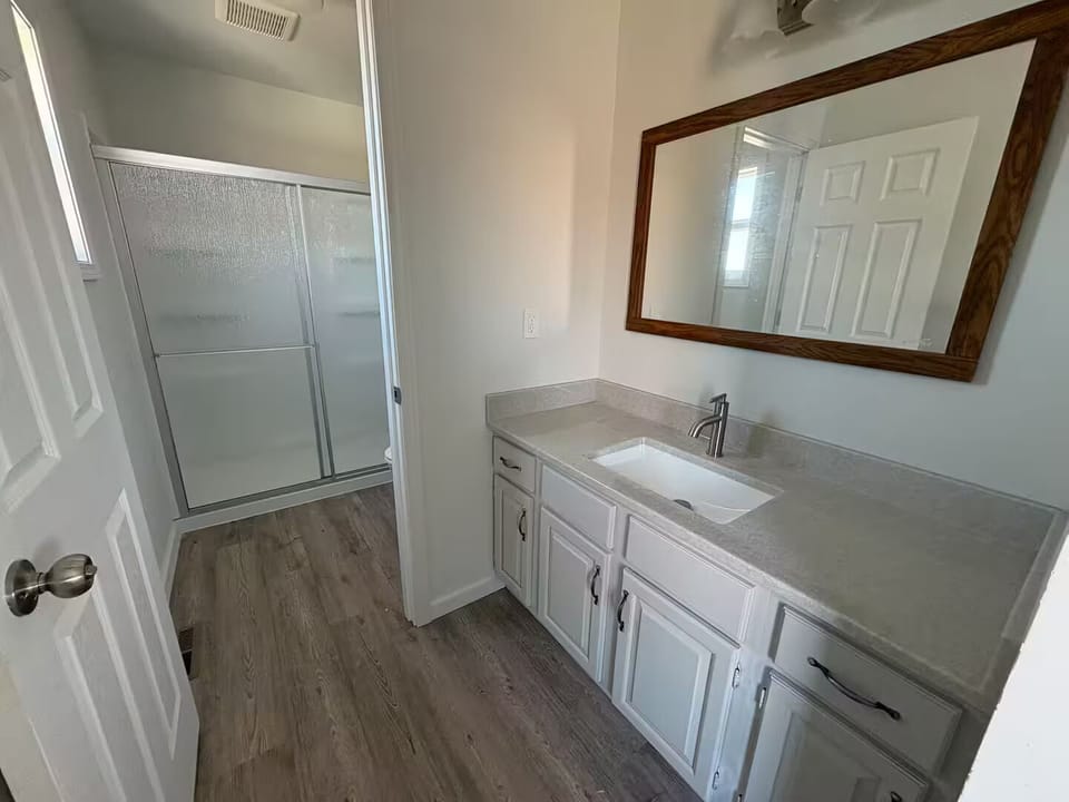 Master bedroom bathroom has a walk in shower along with sink & stool
