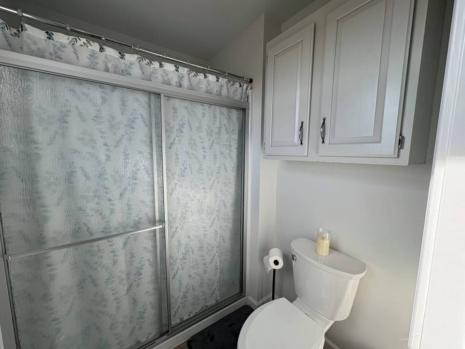 Master bedroom with bathroom which has a walk in shower along with sink & stool