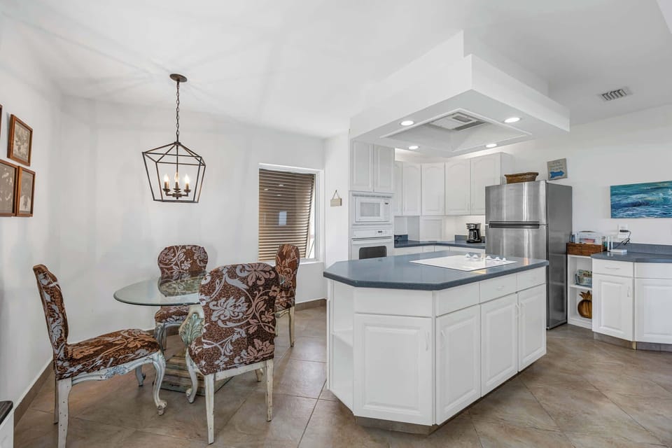 Bright kitchen with a large island and patterned dining chairs