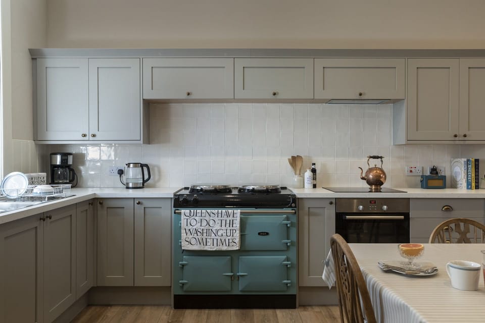 New Ladykirk Farmhouse - the AGA and blue cabinets in the open-plan farmhouse kitchen