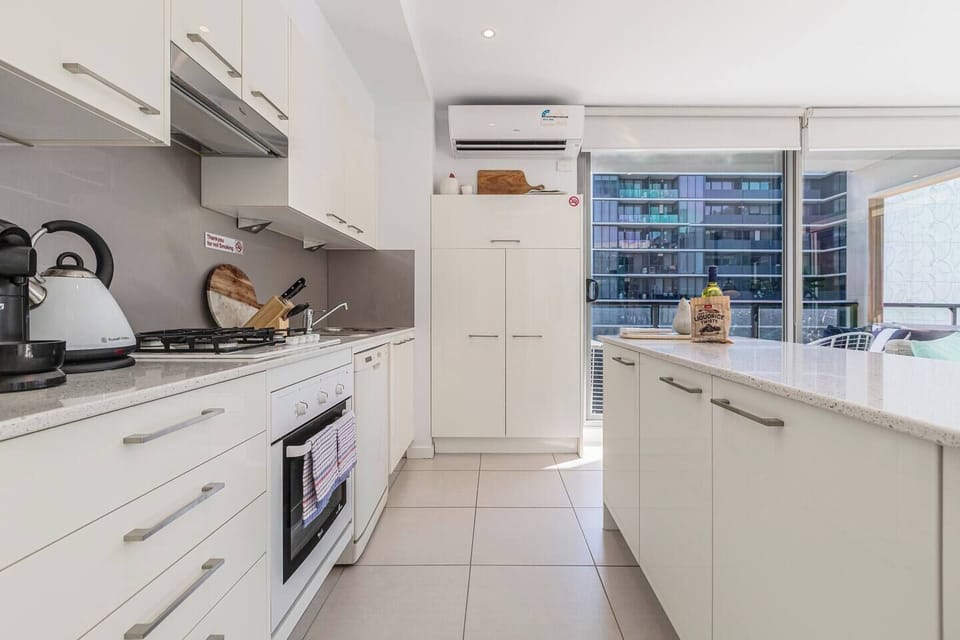 From morning espresso to evening meals, the fully equipped kitchen offers an oven, dishwasher, full-size fridge, and island bench — making home cooking feel easy and inviting.