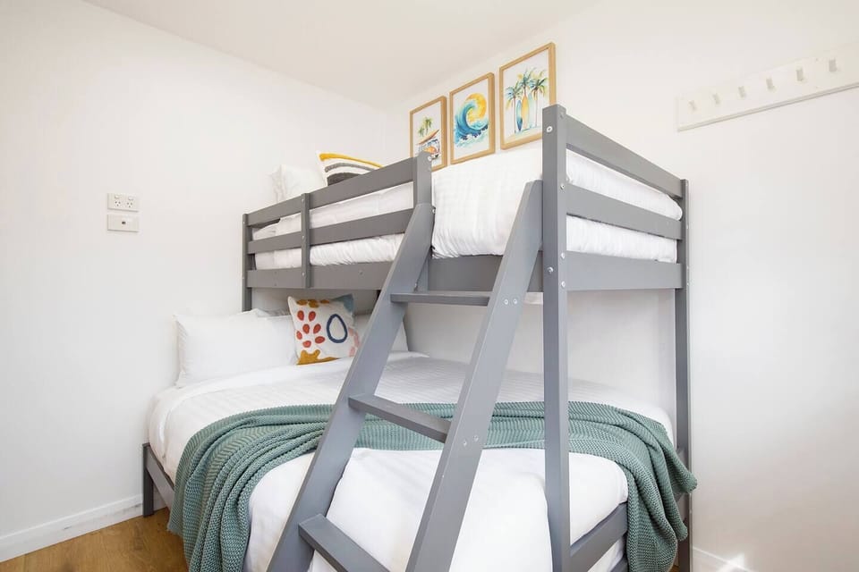 Perfect for friends or families, the second bedroom features a bunk with a double bed below and a single above with cheerful touches.
